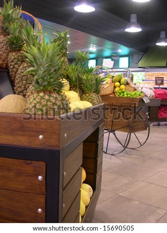 Pineapple basket in a Hypermarket, with a background of vegetables in exhibition.