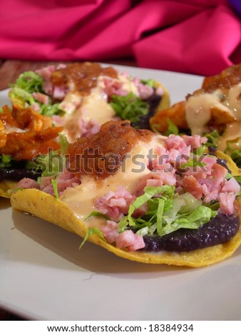 Meat mexican tacos and quesadillas with hot sauce, nachos, jalapenos, fried beans and cheese sauce, in a mexican restaurant
