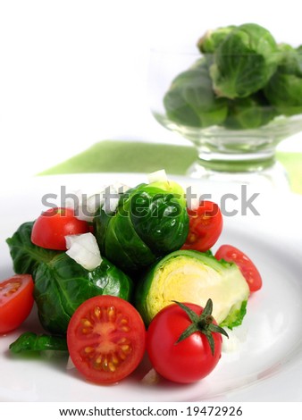 Fresh organic salad of Brussels sprouts and cherry tomatoes, on white dish