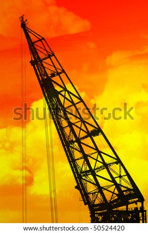 Silhouette of the crane with surrealistic red/yellow sky in the background
