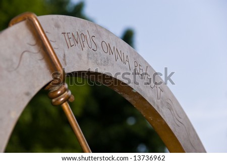 Sundial shot against a background of vegetation. Perfect to show the idea of time flowing.