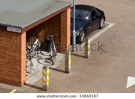 Bicycle shed among cars. July 2008. This bicycle shed is part of an english program to encourage workers to cycle to work instead of using a car in an effort to be more environment friendly.