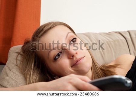 Beautiful blond girl watching tv, is there anything interesting on TV?