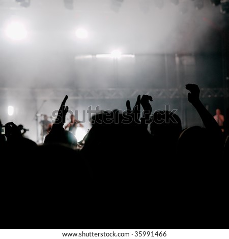 Crowd cheering at a concert. Back-lit. Copy space.