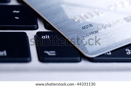 Credit card on laptop. E-commerce concept. Blue toned. Shallow depth of field.