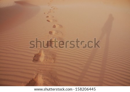 right shadow and foot step on sand dune, Sahara desert, Morocco