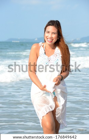 Long hairs beautiful lady walk on the beach and wind blow her hairs