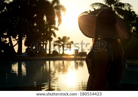 Beautiful long hairs lady in long dress and big beach hat on her morning relax vacation.