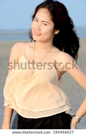 Long hairs beautiful lady walk on the beach and wind blow her hairs.