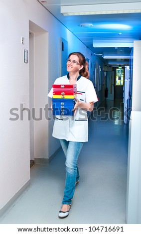 Young scientist walks down the corridor carrying histological samples