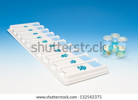 Patient tissue samples on a tray and in tubes on blue gradient background
