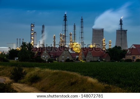 Chemical factory at dawn with rural houses next to it