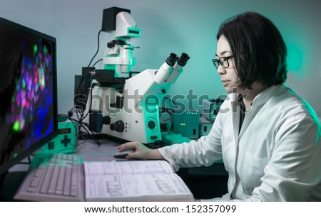 Oriental microscopist works with fluorescent tissue samples