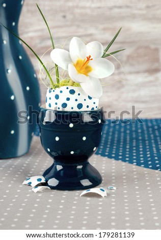 Easter egg vase with open white crocus flower on neutral background
