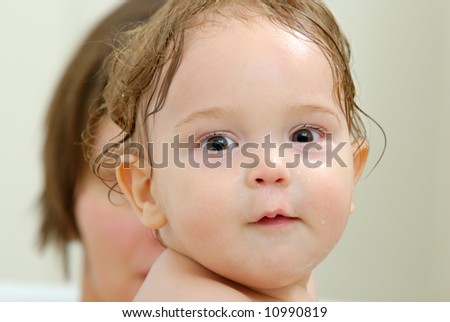 a face of eight month old baby with wet face and hair
