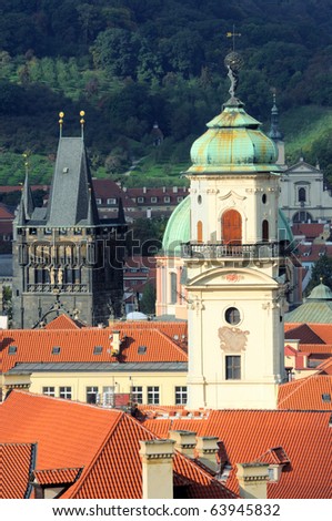 An aerial view towards Powder Gate, including an inner city church tower and rooftops. Bird view from the Old City Hall tower in Prague.