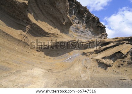 Sandstone twisted into waves by volcanic activity. Structure revealed on the cliffs above the ocean by erosion by wind and waves. El Golfo bay, Western Lanzarote, Canary islands, Spain