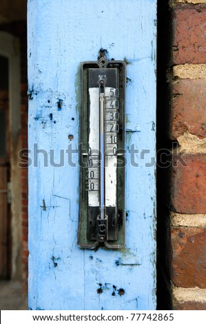 Old thermometer upon the old painted door frame