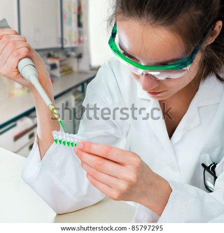 Junior researcher in white coat loads pcr samples in modern laboratory
