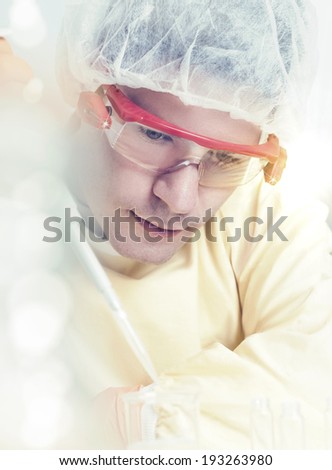 Portrait of a young male scientist with automatic pipette, tinted image