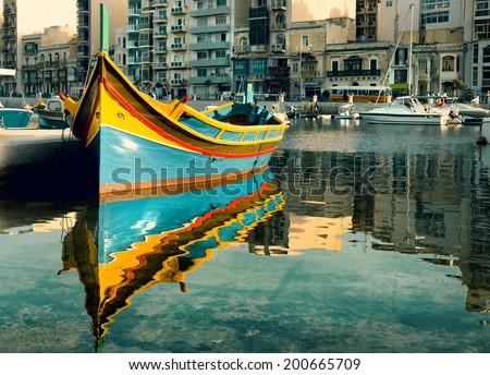 Colorful fishermen\'s boat reflected in water in St. Julian\'s Bay, Malta