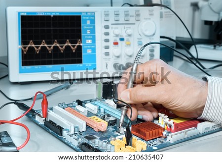Electronics repair service, hands of senior tech reparing an electronic circuit