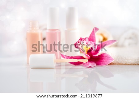 Wellness and body care background. Nail varnish, towels and a single orchid flower