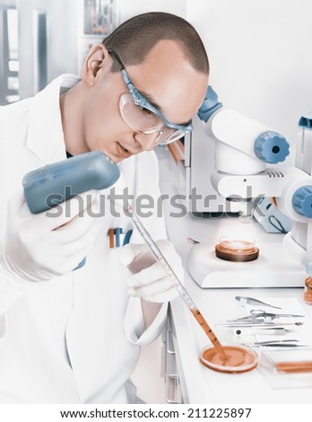 Young scientist in while lab coat works in the lab