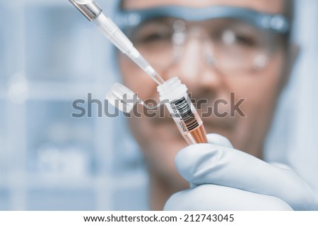 Scientist or tech holds liquid biological sample in gloved hands