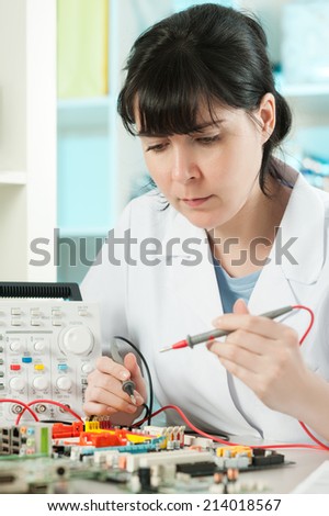 Tech repairs electronic device in modern laboratory