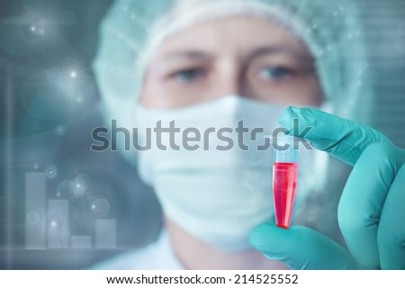Scientist or tech holds liquid biological sample in gloved hands