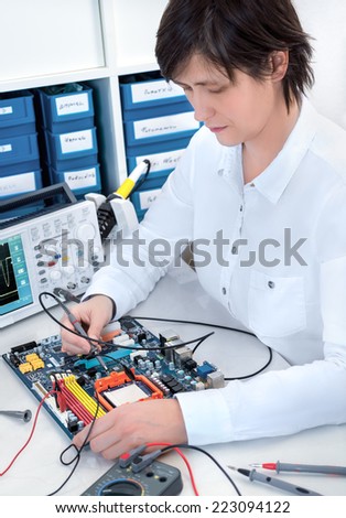 Senior electronics repairman works at hardware repair center