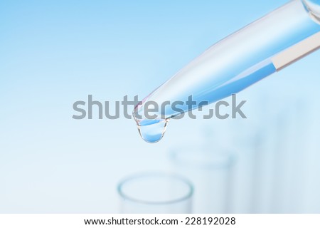 Scientific background: drop from pipette falling in a tube, text space