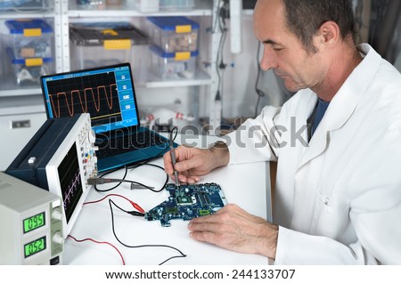 Senior male tech works in hardware repair facility