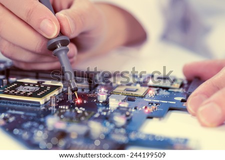 Technological background with closeup on tester checking motherboard. Toned image. Shallow DOF, exact focus on the tester tip