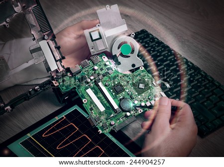 Male tech fixes motherboard of portable computer