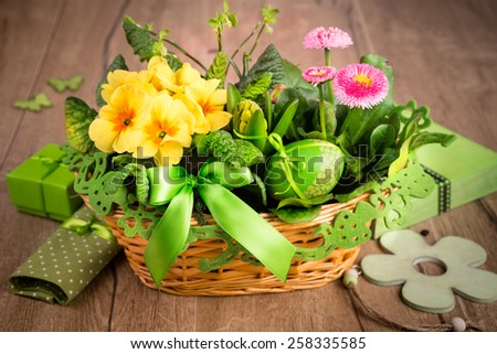 Easter basket on wooden table with handmade decorations and Easter egg