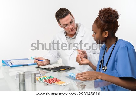 Doctor explains to the nurse appropriate medications for his patient. Shallow DOF, focus on the face of the doctor.