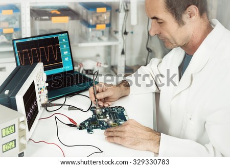 Senior male tech works in hardware repair facility. This image is toned