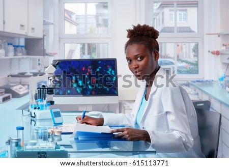 Female African scientist, medical worker, tech or graduate student works in modern biological laboratory. This image is toned.
