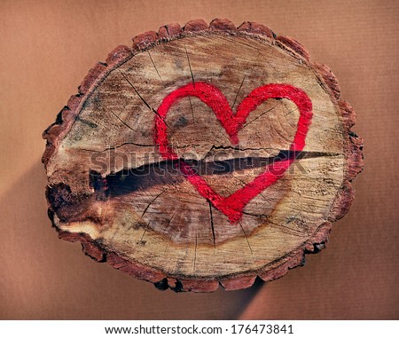 Love and save nature, red heart drawn on a tree trunk. Stop deforestation.