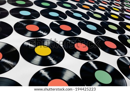 Music - Vinyl records. Colorful collection of vinyl records, LPs, on grey background, angle view. The labels can be easily customized, the image is suitable for background use.