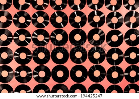 Music - Vinyl records. Collection of vinyl records, LPs, on red background, top view. The labels can be easily customized, the image is suitable for background use.