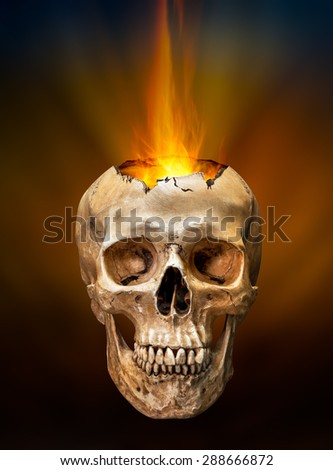 Beam of fire blaze burst out from internal broken human skull on dark background