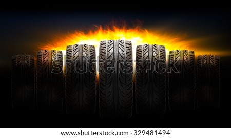 Rubber car tire with fire blaze on dark background