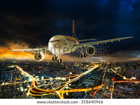Airplane for transportation flying over the night scene city on beautiful sunset background