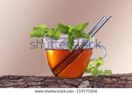 Cup of tea with peppermint and brown background