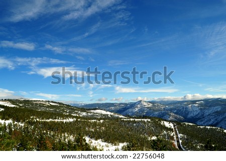 Looking over the forest and mountain tops of the California Sierra Nevada mountains, image contains GPS location information