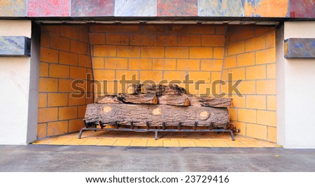 Natural gas fired outdoor fireplace with ceramic logs on a steel grate