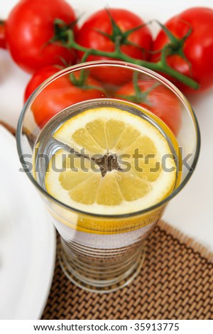 Glass of cold water with a slice of fresh lemon for a refreshing flavor.